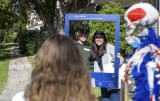 Dois visitantes no jardim a pousar para a fotografia a segurar uma moldura