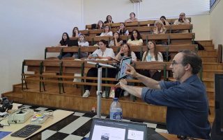 estudantes a assistir a uma apresentação sentados na sala de aula