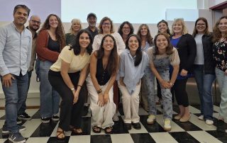 Grupo de estudantes e professor na sala de aula a pousar para a fotografia