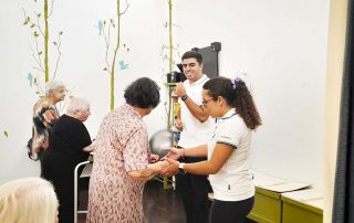 Grupo de idosos a dançar em pé, juntamente com docentes e alunos da Escola Superior de Saúde do Alcoitão