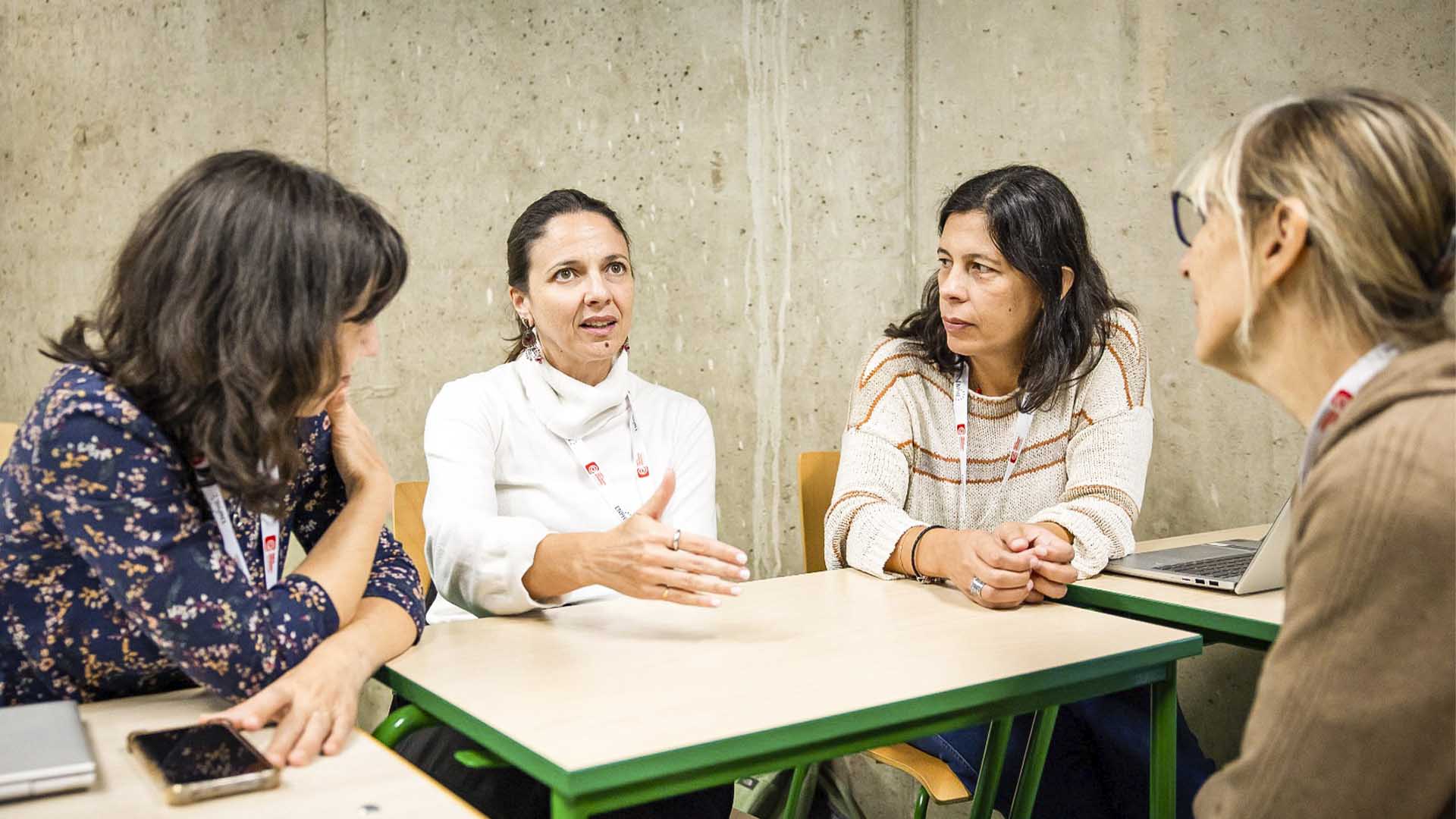 Grupo de senhoras ao redor de uma mesa a discutir ideias