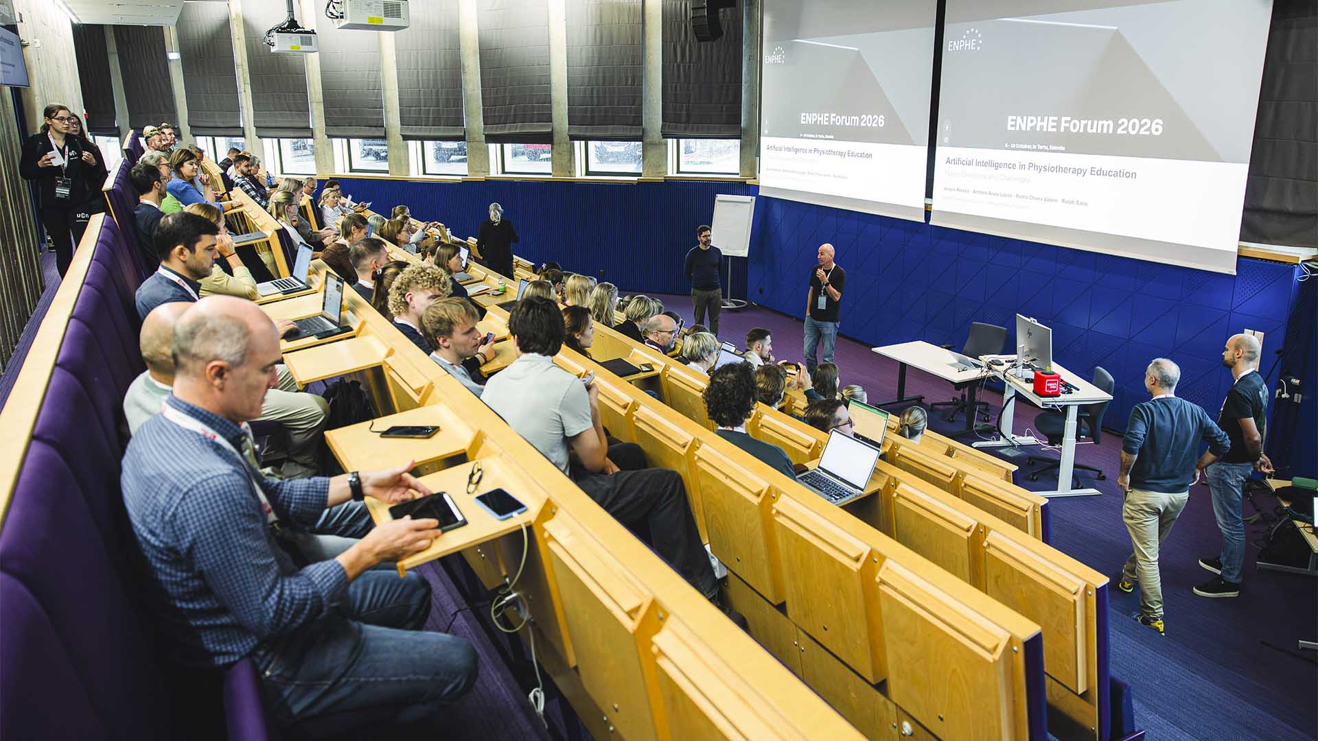 Plateia do "ENPHE Forum 2026" nas cadeiras num auditório e computadores