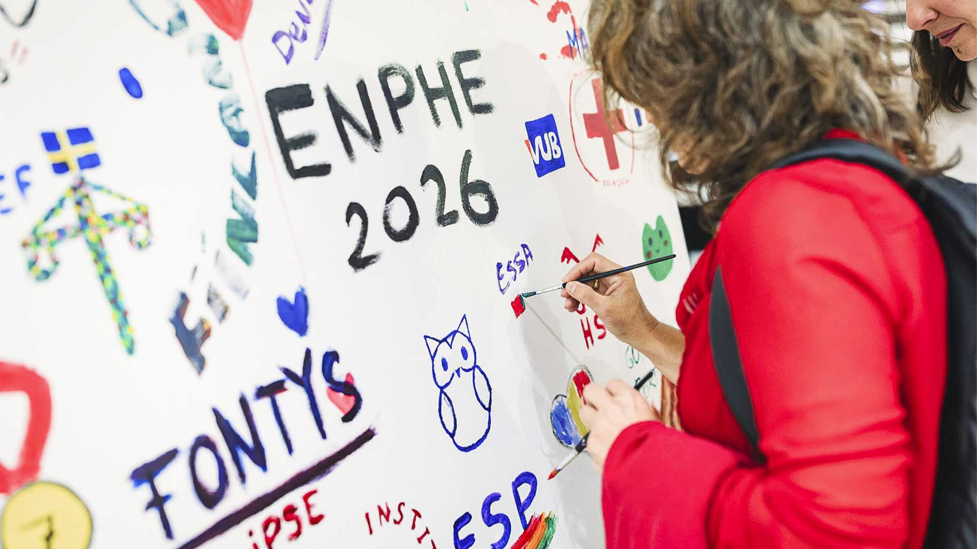 Mulher a pintar numa tela grande, com um pincel e tintas, "ESSA" e a bandeira de Portugal